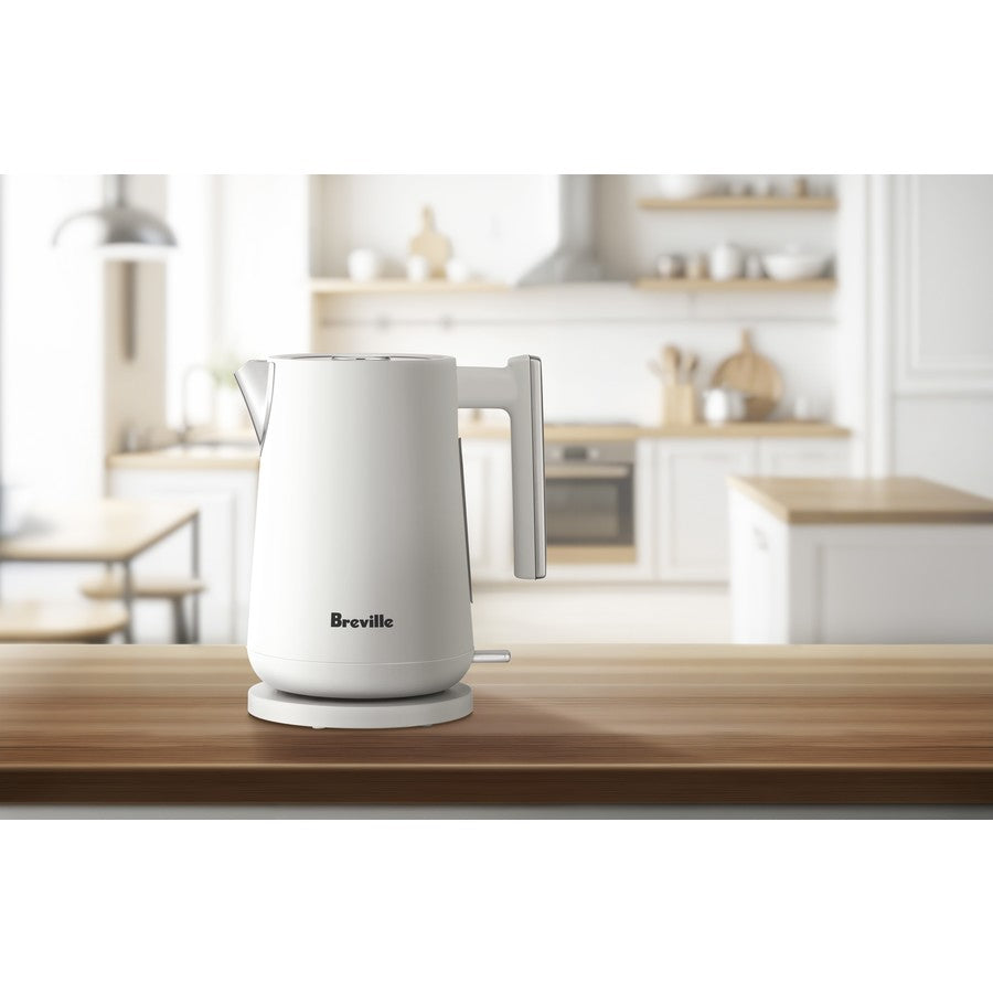 White Breville kettle on a wooden kitchen counter with a blurred background