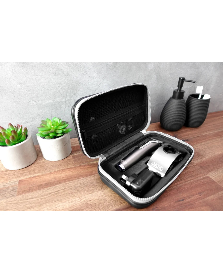 Hair trimmer set in a black carrying case on a wooden surface with a gray wall background.