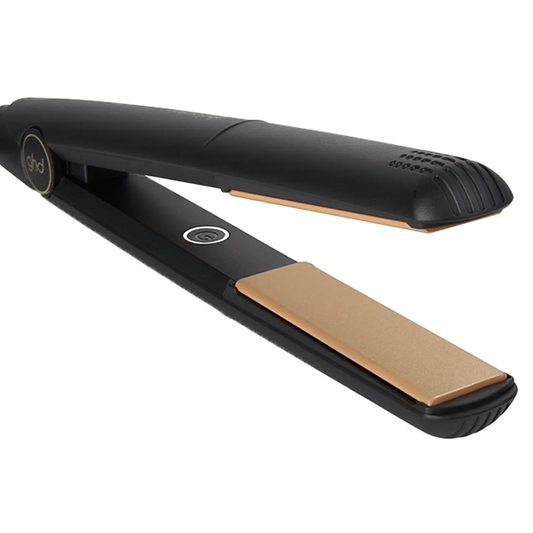 Black and gold hair straightener on a white background