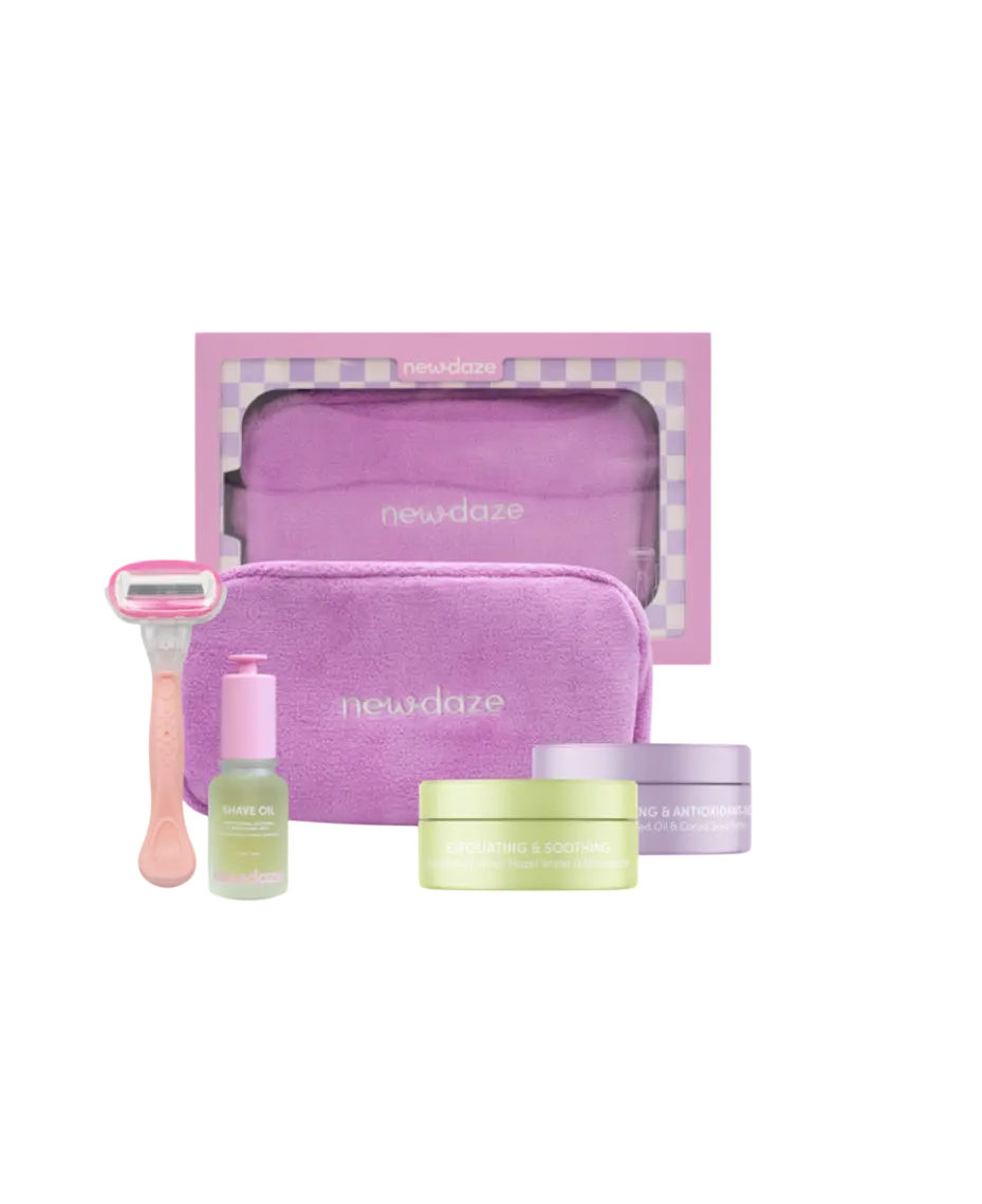 Skincare set with purple pouch, razors, and bottles on a white background