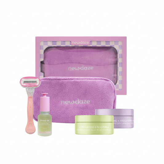 Skincare set with purple pouch, razors, and bottles on a white background