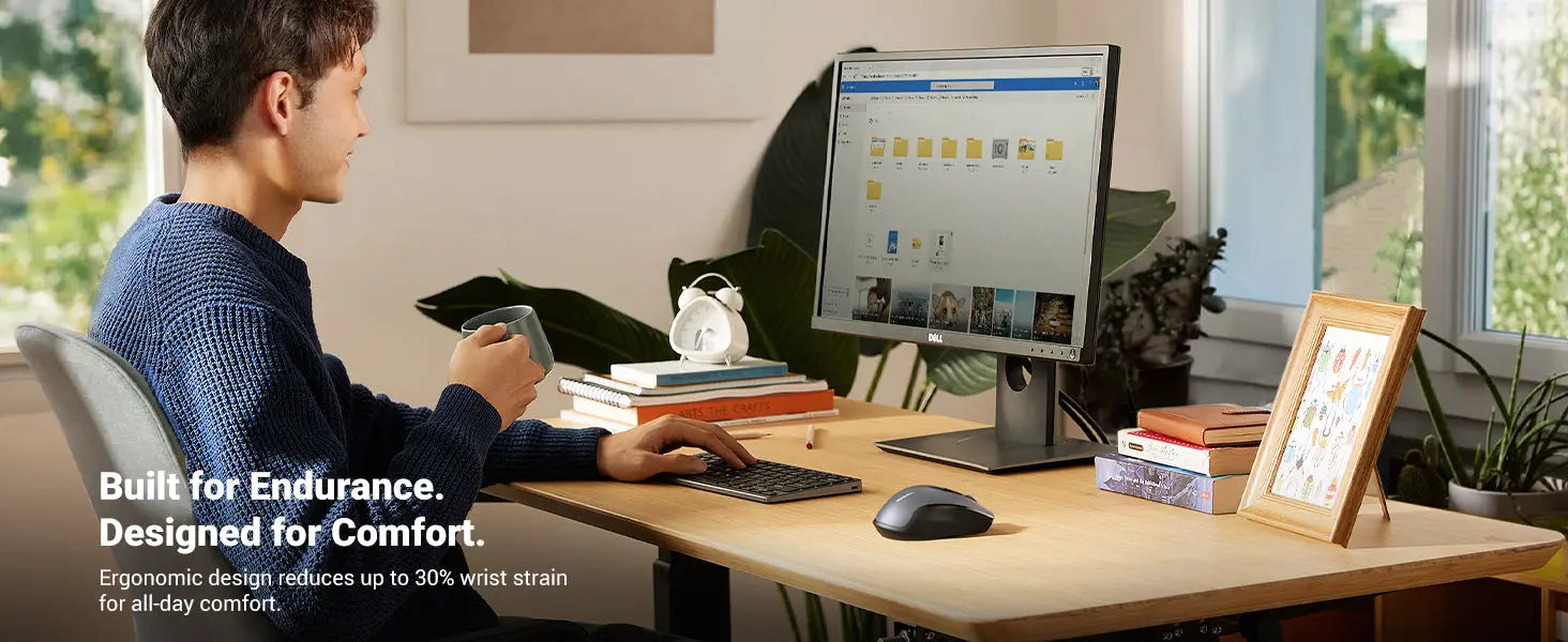 Person using a computer at a desk with ergonomic equipment, surrounded by books and decor.