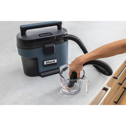 Shark vacuum cleaner being used to clean a glass on a white surface