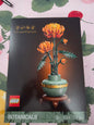 LEGO Botanicals Chrysanthemum building set box, showing the assembled orange chrysanthemum flower model on a dark background with LEGO branding and product details at the bottom.
