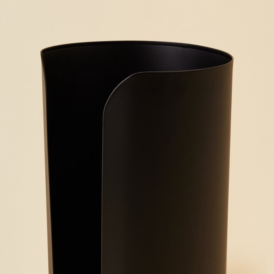 Black cylindrical vase on a beige background