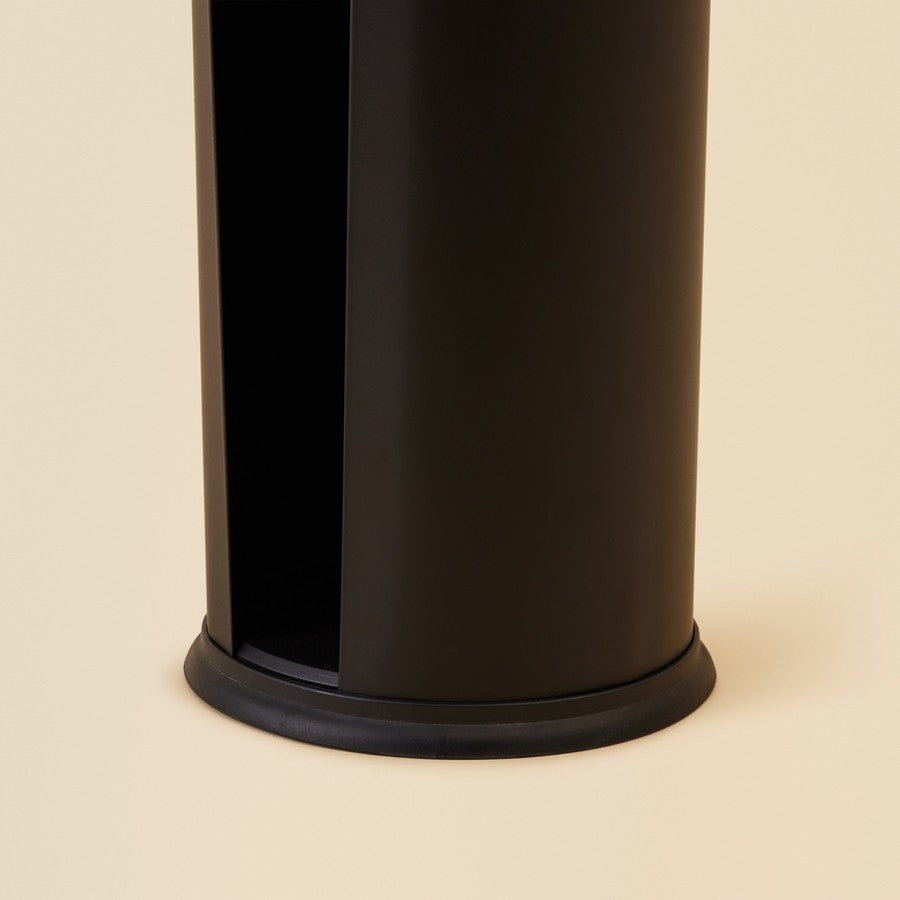 Black cylindrical toilet paper holder on a beige background