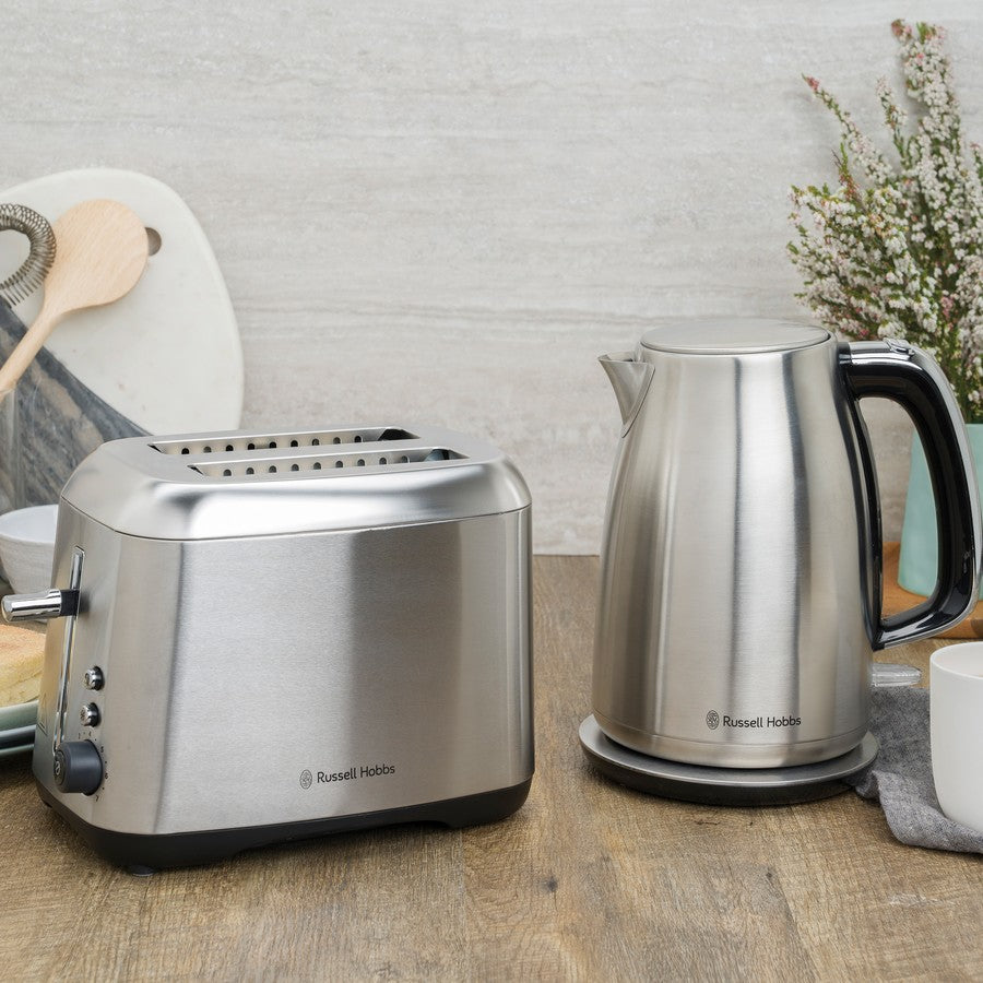 Stainless steel toaster and kettle on a kitchen counter with a neutral background