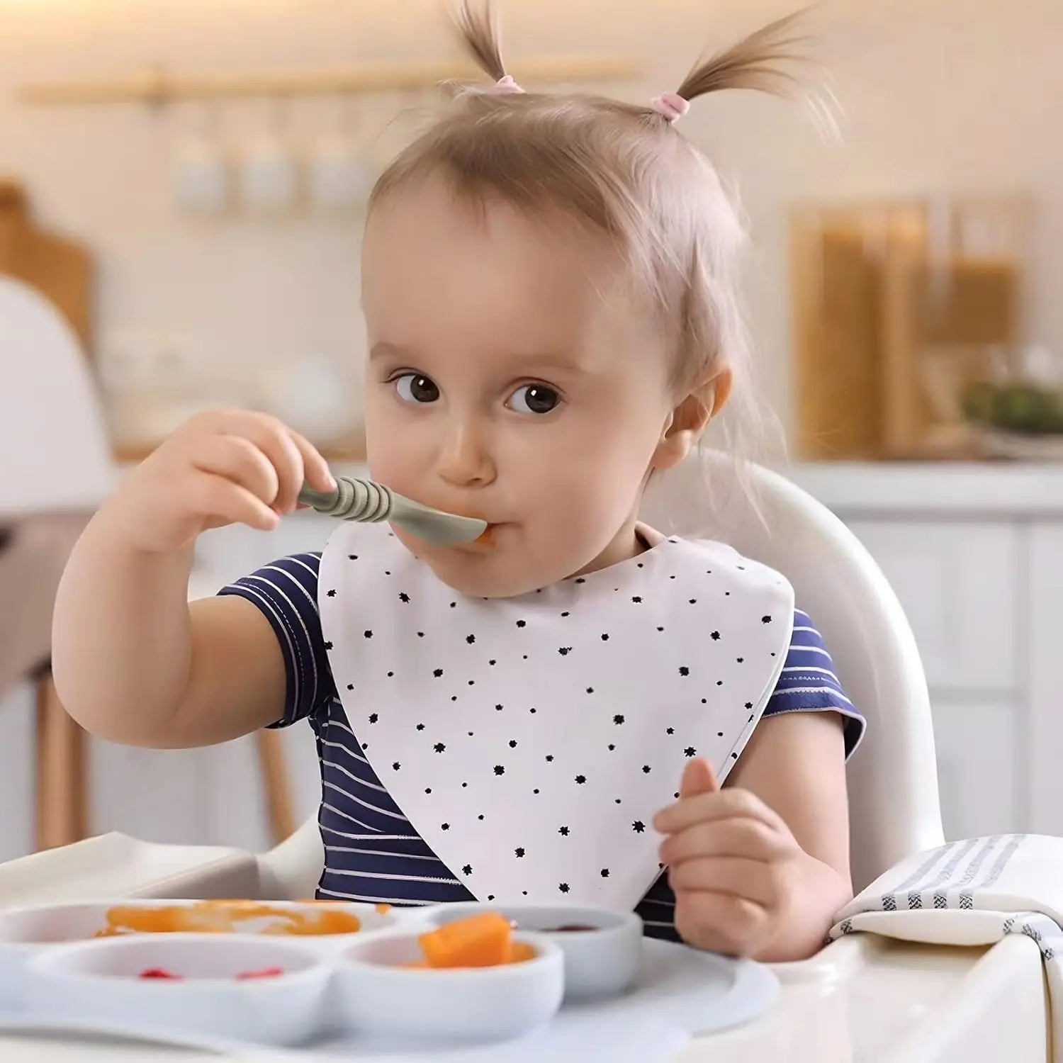 Child eating with a spoon in a kitchen setting