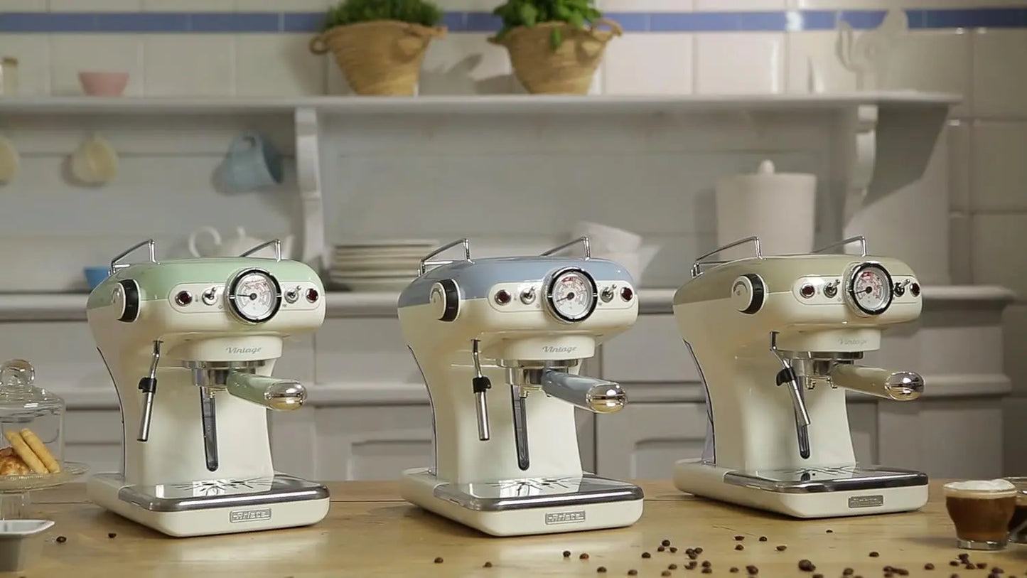 Three vintage-style espresso machines on a kitchen counter with a tiled wall background.