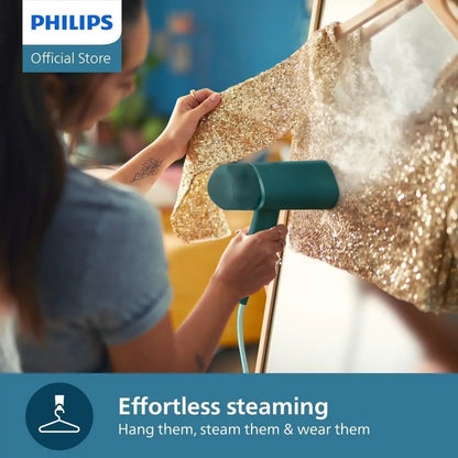 Person using a steam iron on a gold sequin garment with Philips branding.