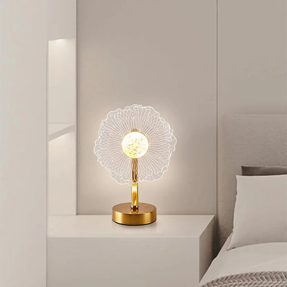 Decorative table lamp with floral design on a nightstand in a bedroom setting.