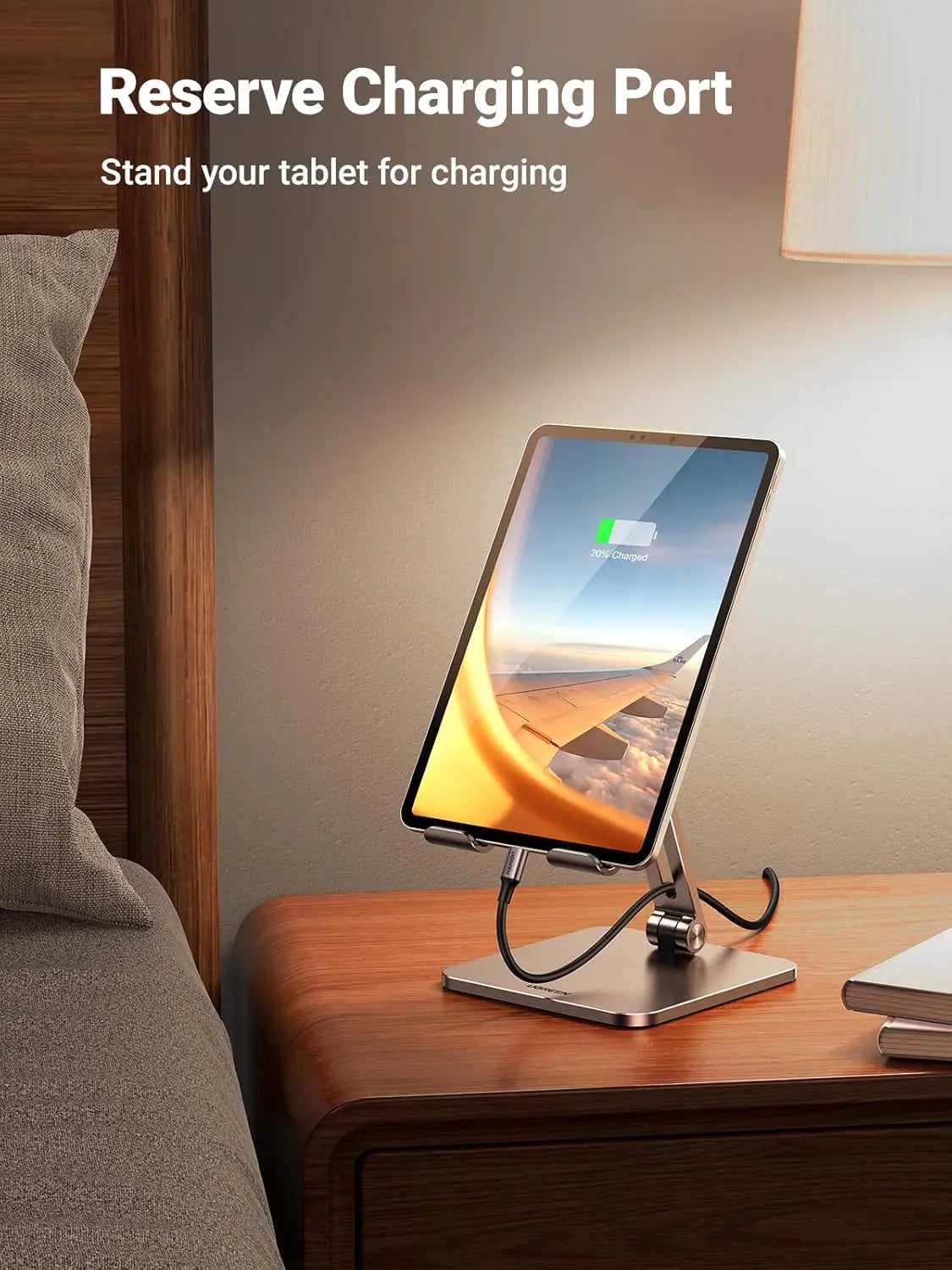 Phone stand with charging port on a nightstand next to a bed