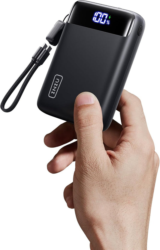 Black power bank with digital display held by a hand on a white background