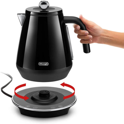 Black electric kettle being held above a matching base on a white background