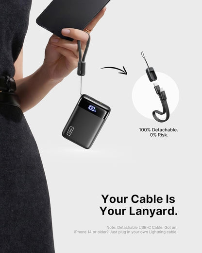 Person holding a black power bank with a detachable USB-C cable, emphasizing its detachability.