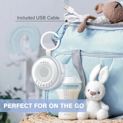 Portable speaker with included USB cable, baby bottle, and plush toy on a light blue bag.