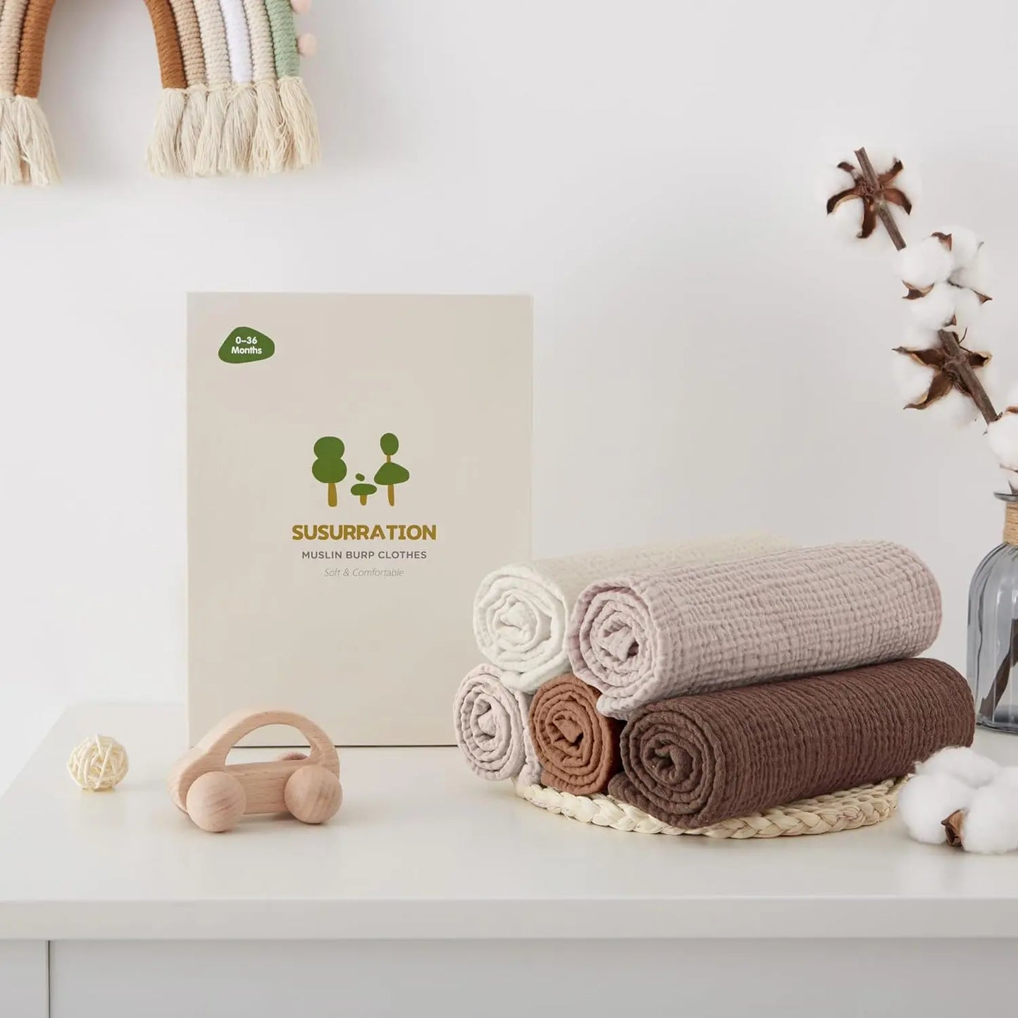 Baby products including wraps and a box with 'Susurracion' branding on a white surface.