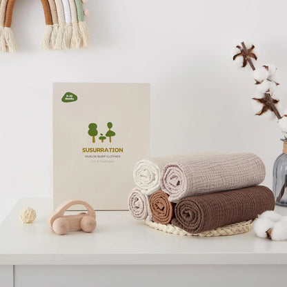 Baby products including wraps and a box with 'Susurracion' branding on a white surface.