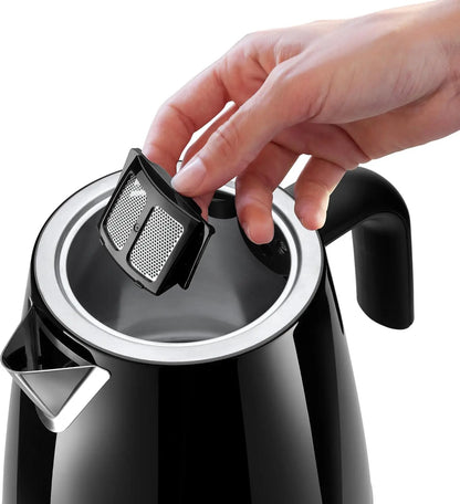 Black electric kettle with a hand holding a black and silver filter.