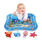 Baby playing on an inflatable water mat with ocean-themed graphics and toys.