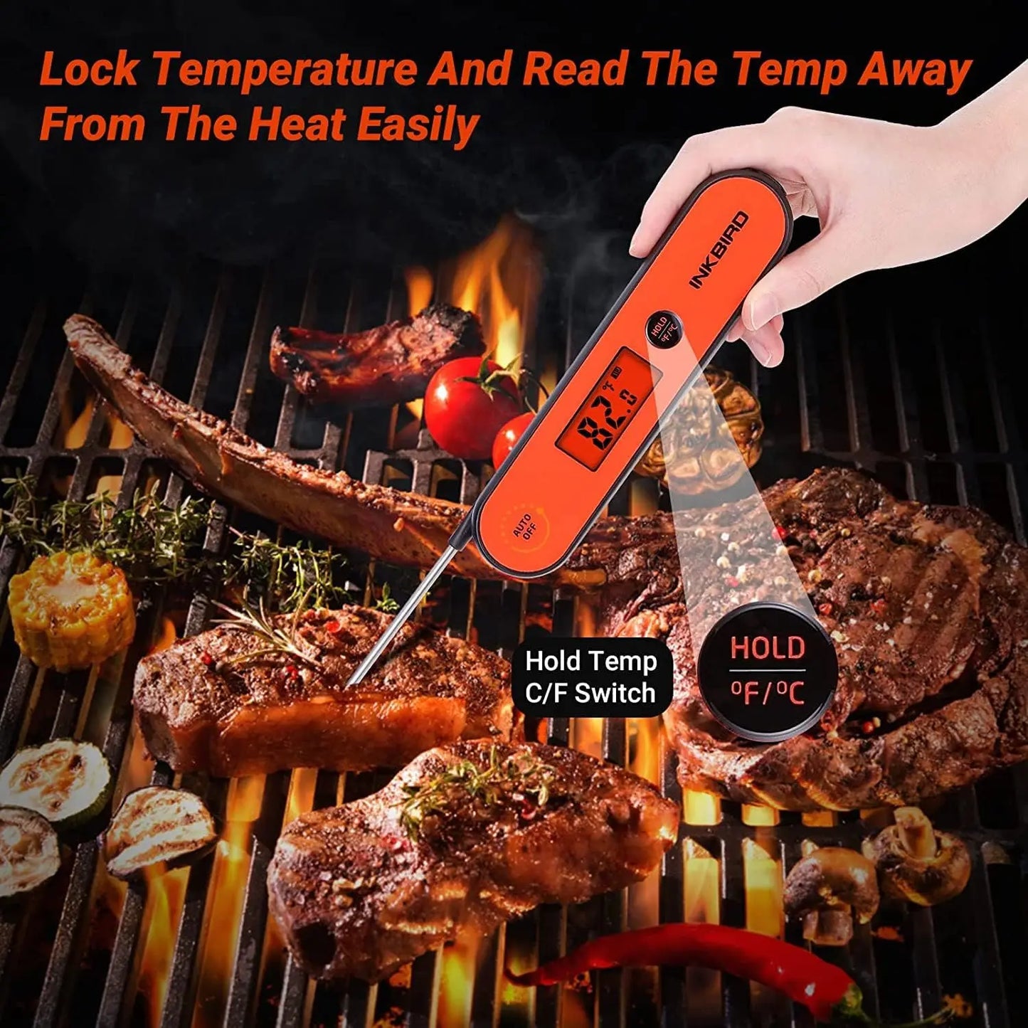 Digital thermometer being used on a grill with meat and vegetables.