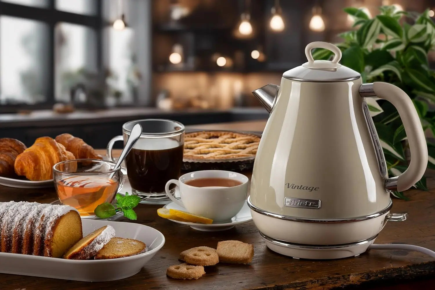Vintage-style electric kettle on a kitchen counter with coffee and pastries.