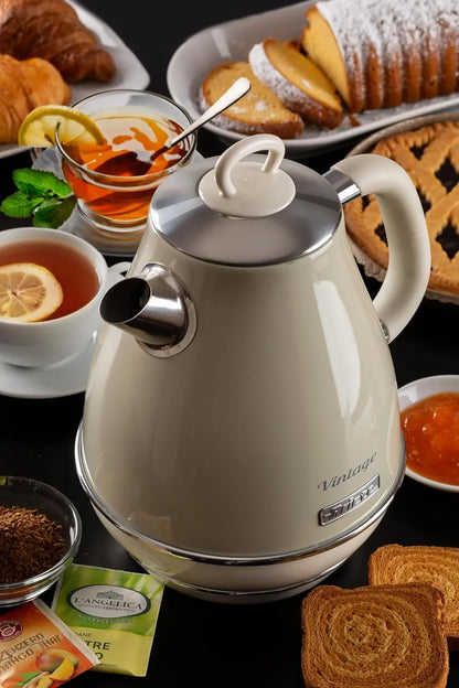 White electric kettle on a table with tea and pastries