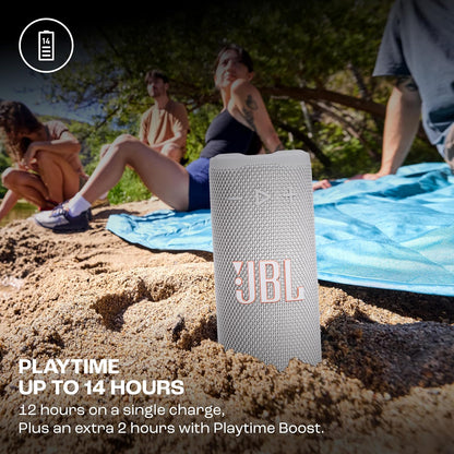 JBL speaker on sand with people in the background