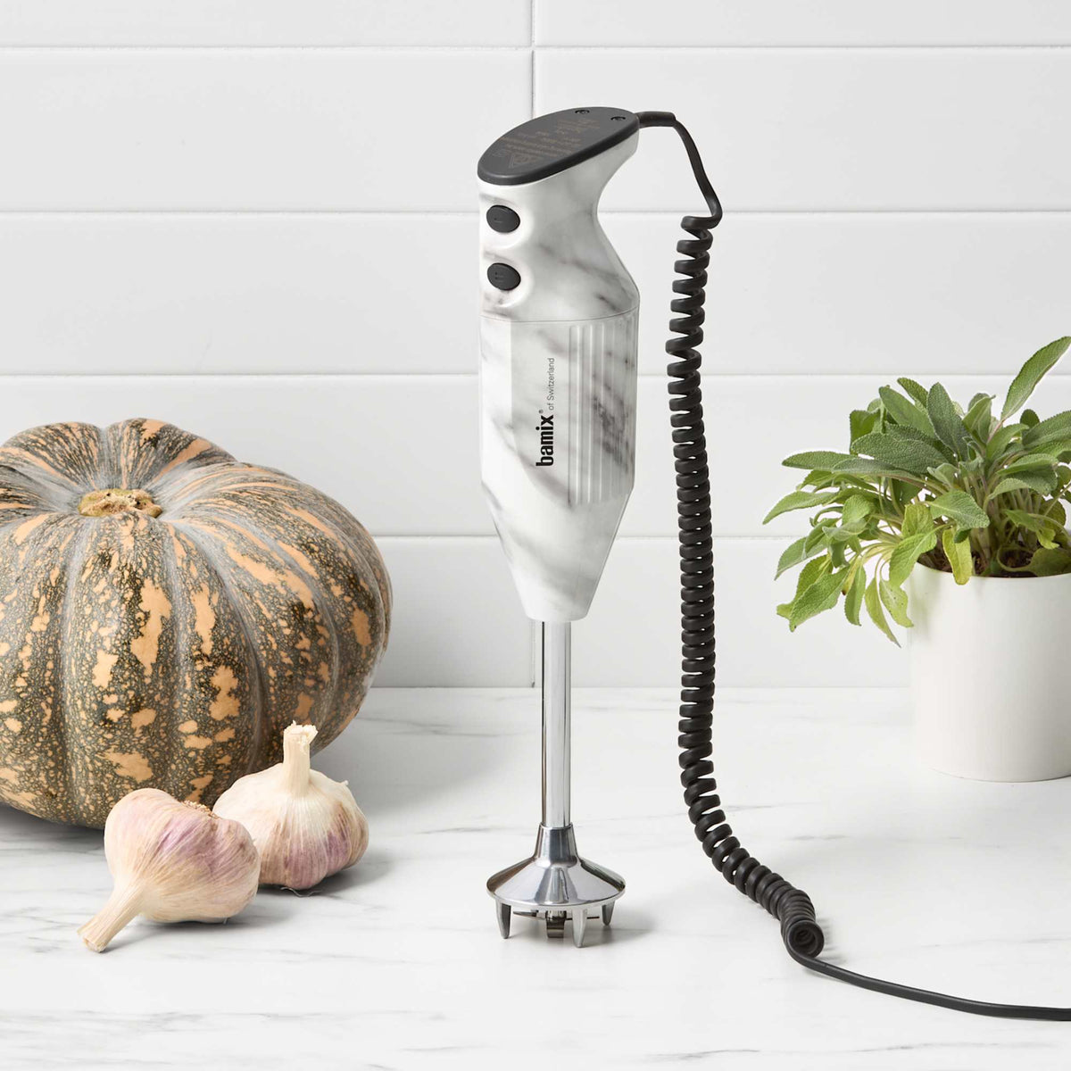 Bamix Swissline Hand Blender 200W White Marble standing upright in a kitchen with pumpkin and garlic