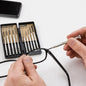 Person adjusting eyeglasses with a set of small tools on a white background