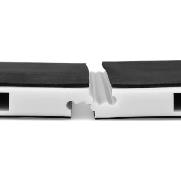 Close-up of a white plastic channel with black textured foam or rubber pads on top, shown against a plain white background.