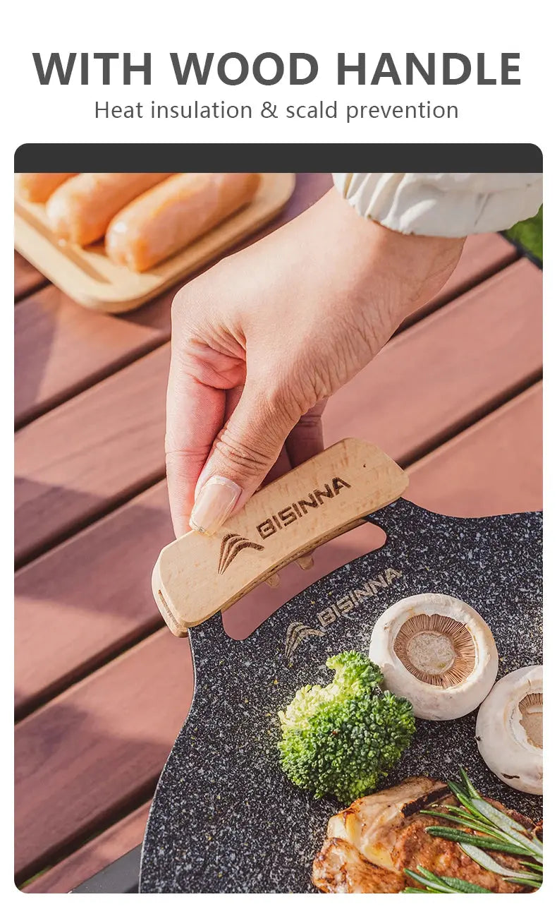 Hand holding a cooking tool with Bisinna branding on a grill with food.