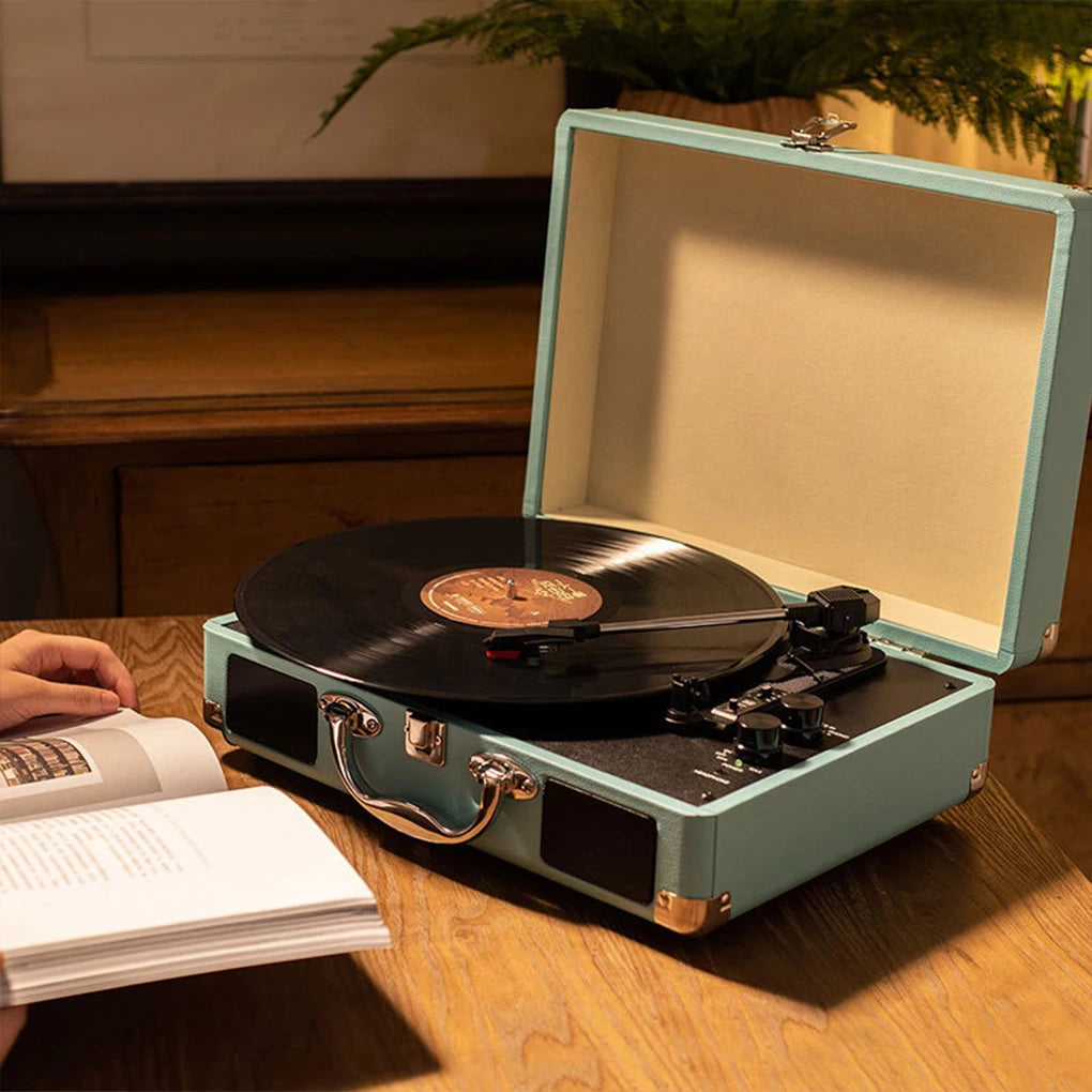 Black vintage record player with ruby stylus and built-in speakers in a living room