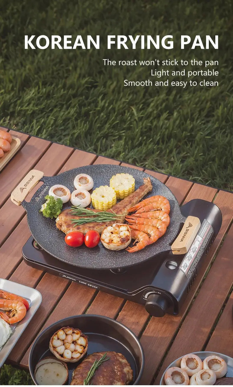 Korean frying pan with food on a wooden table outdoors