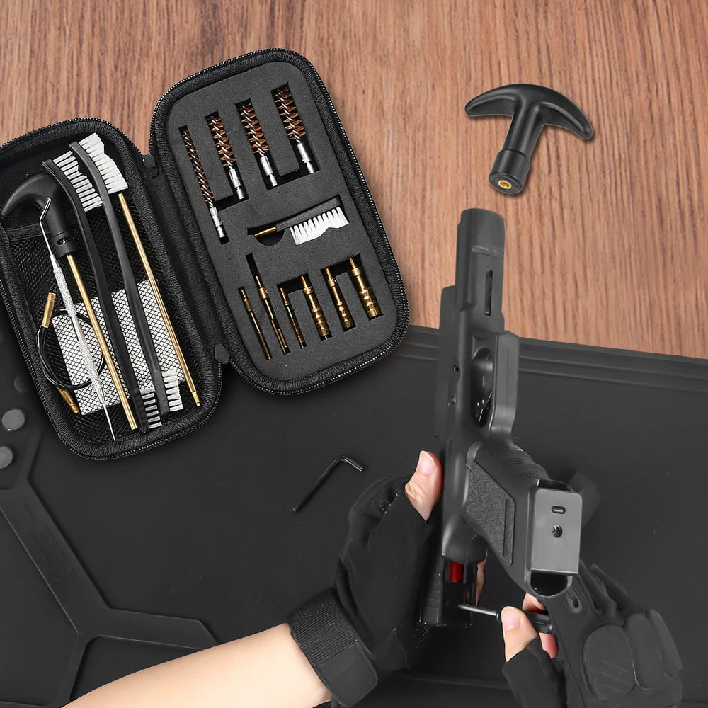A handgun cleaning kit laid out on a wooden surface, including an open black zip case with brushes, rods, and tools, plus a T-shaped tool and small wrench. A person's gloved hands are holding a handgun to demonstrate use.