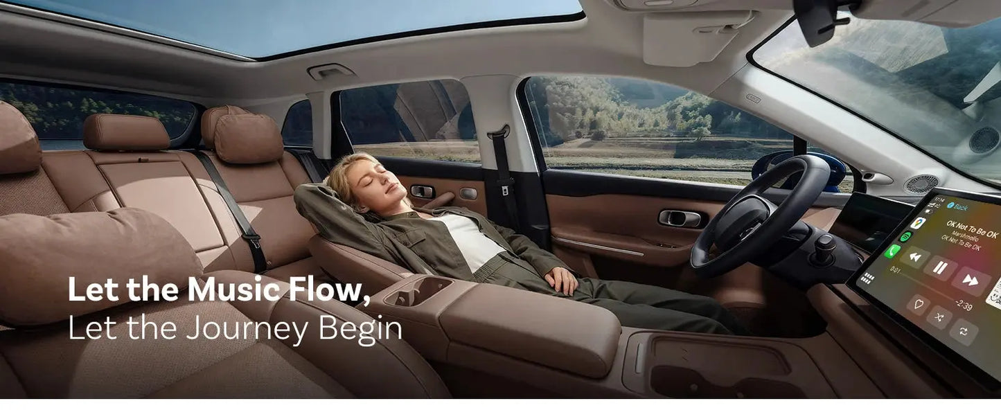 Interior of a car with a person using the driver's seat, featuring a large touchscreen display.