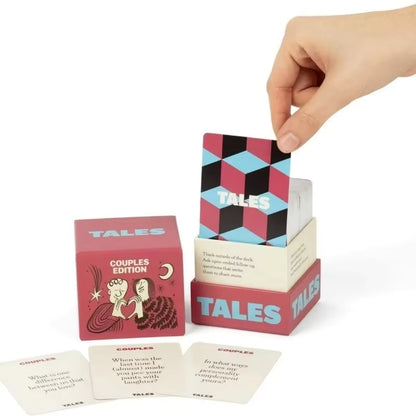 Hand placing a question card back into the TALES Couples Edition box, with sample question cards displayed in front