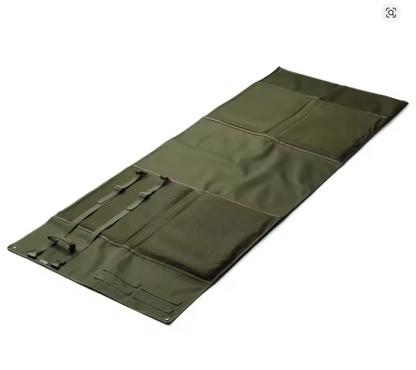 Tactical shooting mat laid out flat, angled view showing full length and gear pouches, green