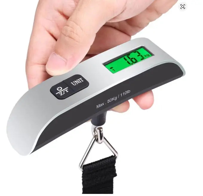 Digital luggage scale held by a hand with a white background