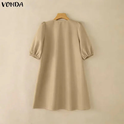 Beige dress on a wooden hanger against a beige background with 'VONDA' branding.