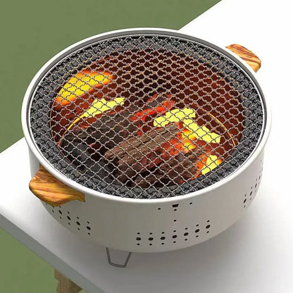 Portable grill with glowing coals on a white surface
