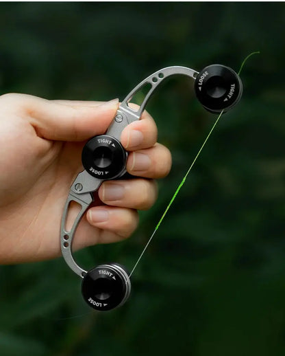 Hand holding a bow stringer tool against a blurred green background