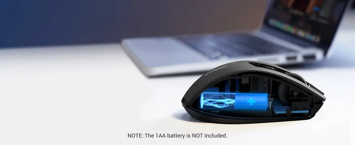 Gaming mouse with TAA battery compartment on a desk with a laptop in the background