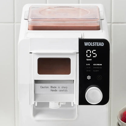 A white Wolstead ice cream maker with a black digital control panel and a clear container filled with pink ice cream, set against a white tiled background.