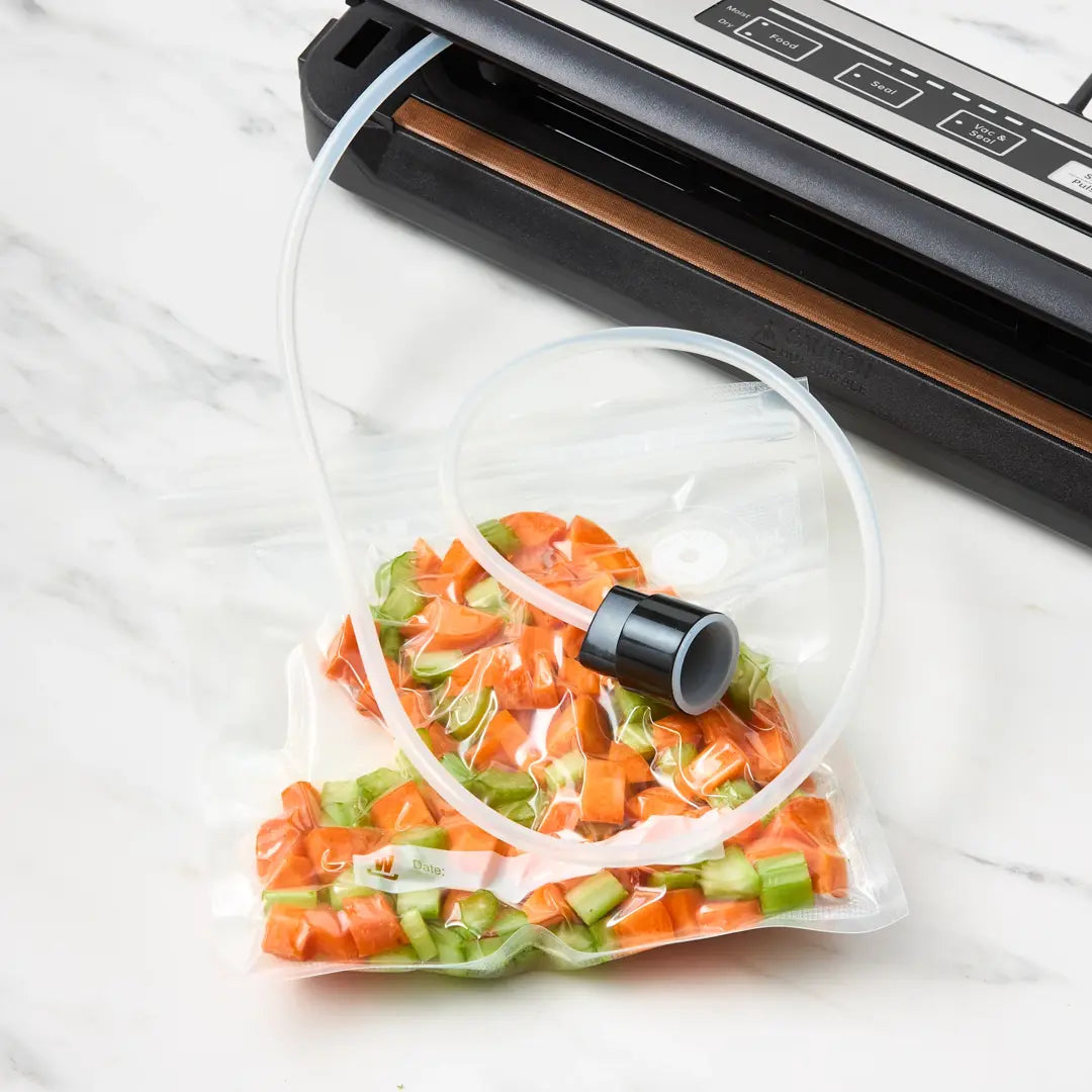 Vacuum sealer with a bag of sliced vegetables on a white surface