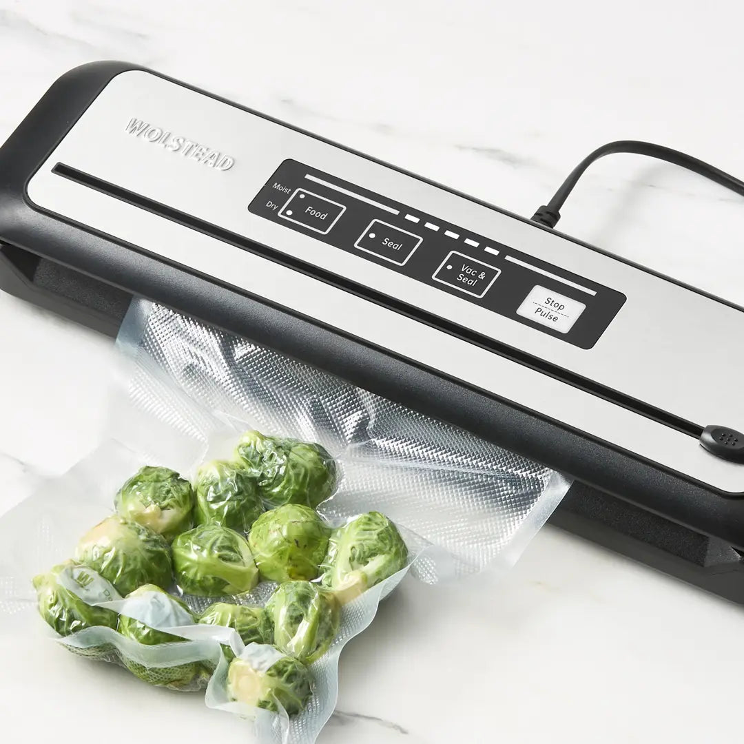 Vacuum sealer with Brussels sprouts in a bag on a white surface