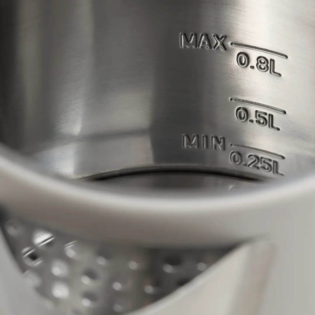 Close-up of a metal measuring cup with volume markings.