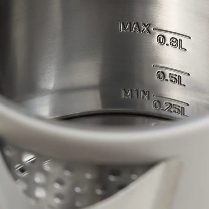 Close-up of a metal measuring cup with volume markings.