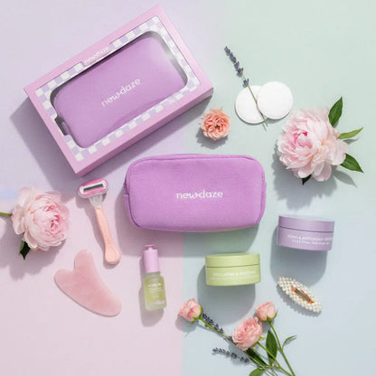 Purple skincare products and tools with 'new daze' branding on a light pink background with flowers.