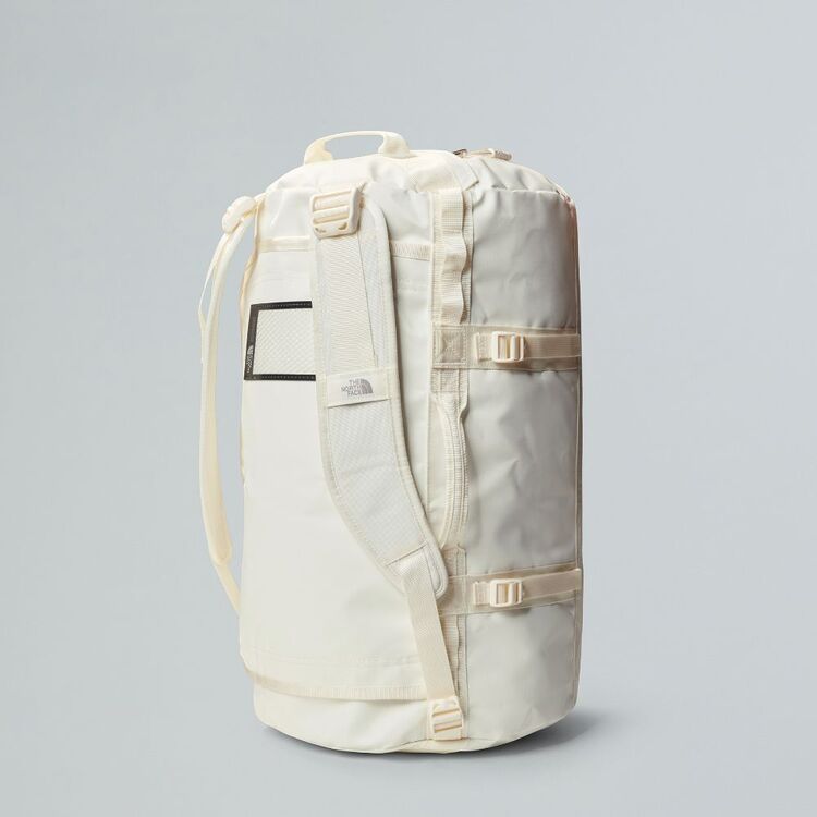 White backpack with a rolled-up mat on a gray background